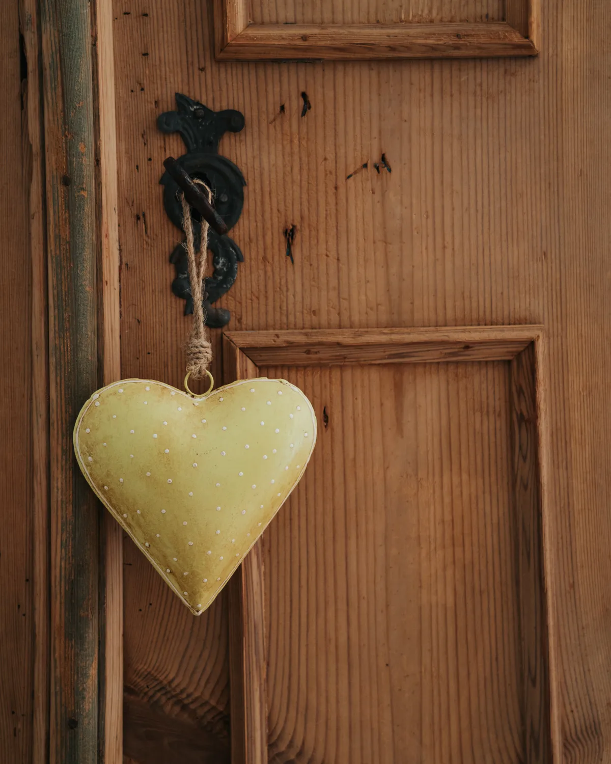 Un piccolo cuore di tessuto appeso al mobile in legno
